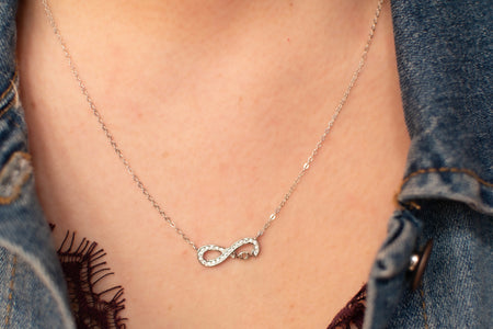 Modelo con collar de cadena y pendiente de infinito con palabra mamá- Mom en plata 925