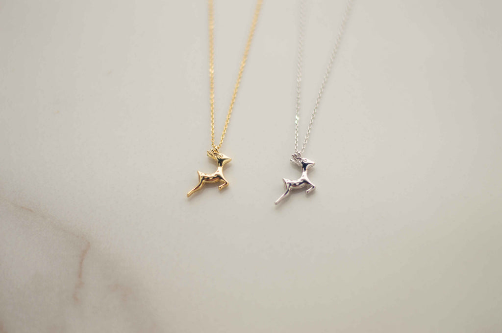 Detalle de pendiente de venado en baño de oro 18k y venado en plata 925