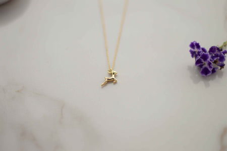 Detalle de pendiente de venado en baño de oro 18k