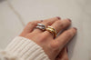 Mano con anillo abierto grueso en plata 925 y anillo abierto grueso en baño de oro 18k