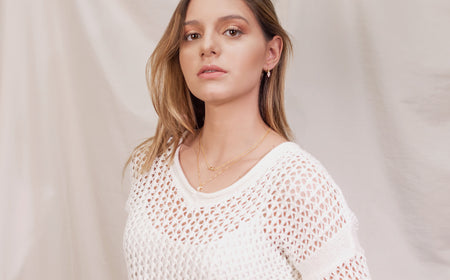 Modelo con Aretes de argolla pequeña con pendiente de mano con zirconias en baño de oro 18k