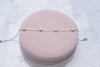 Pulsera con corazones en plata 925 sobre superficie rosa